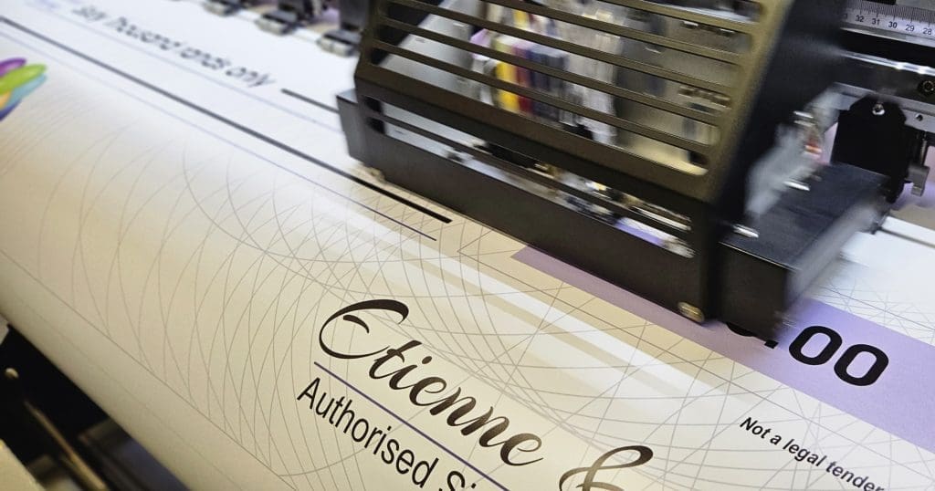 A professional printing process in action, showing a custom Award Cheque being printed on a high-quality machine, highlighting Lazer Art & Frame's printing quality.