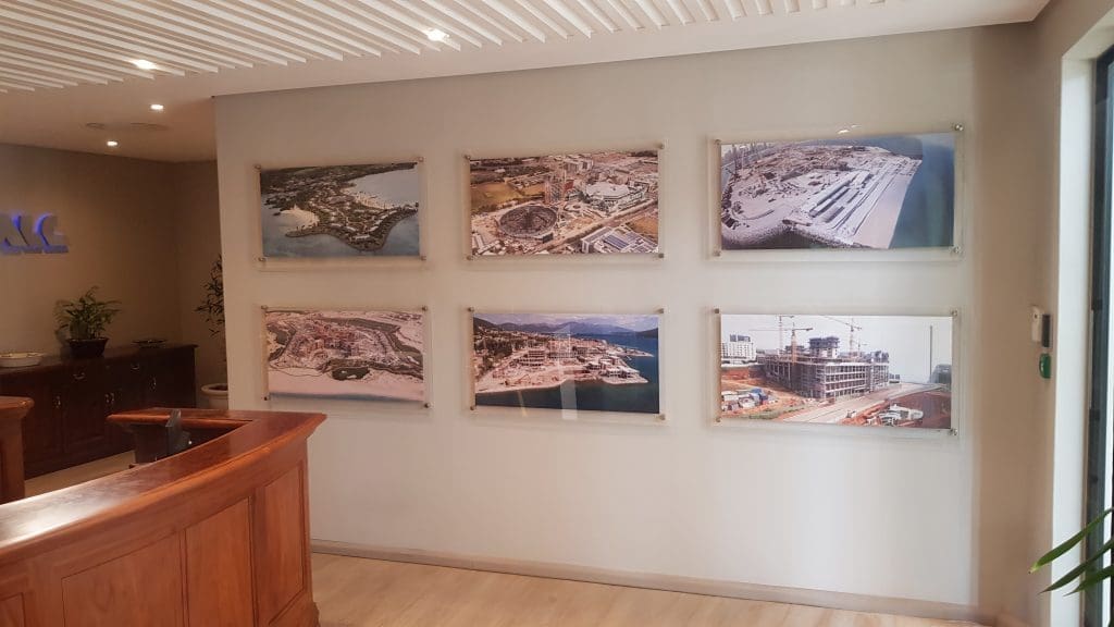 A wall display of six architectural photos in sleek Frameless Frames with standoffs, showcasing a professional look for an office or lobby.